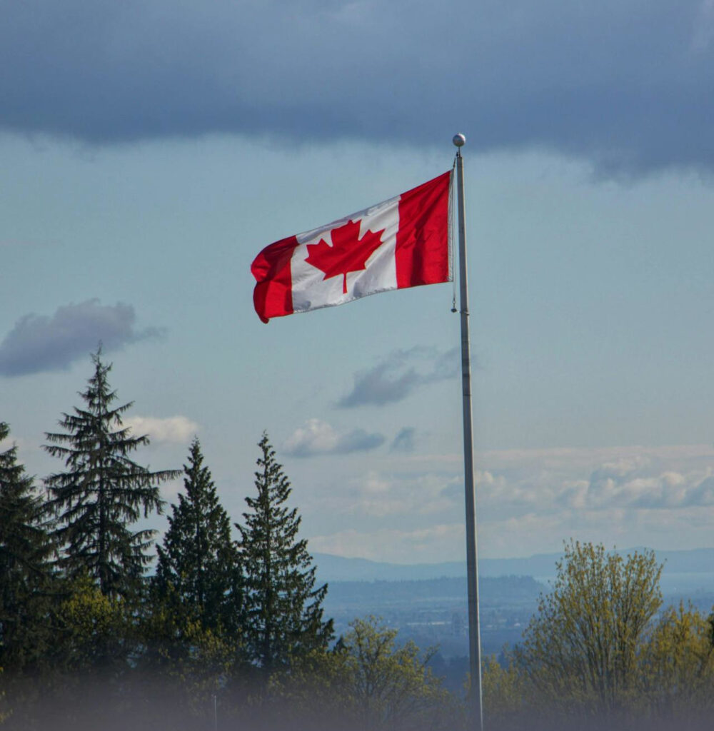 Canadian flag waving high above the trees